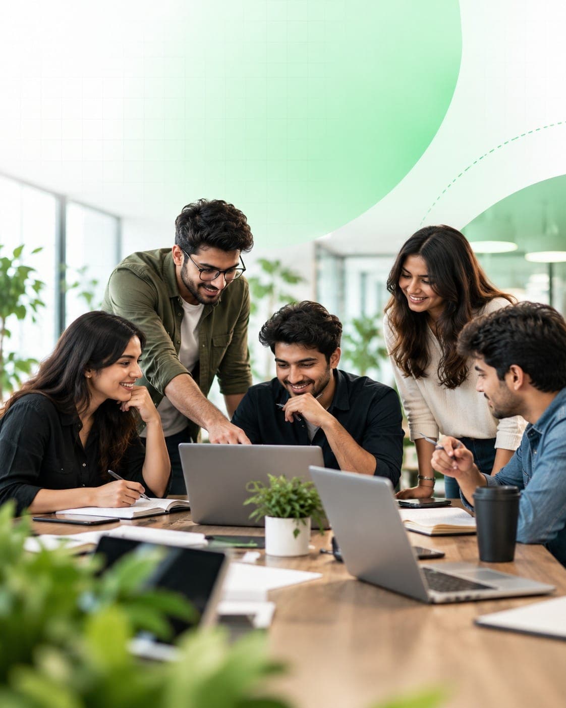 Smiling team gathered around laptops, planning a digital growth strategy together